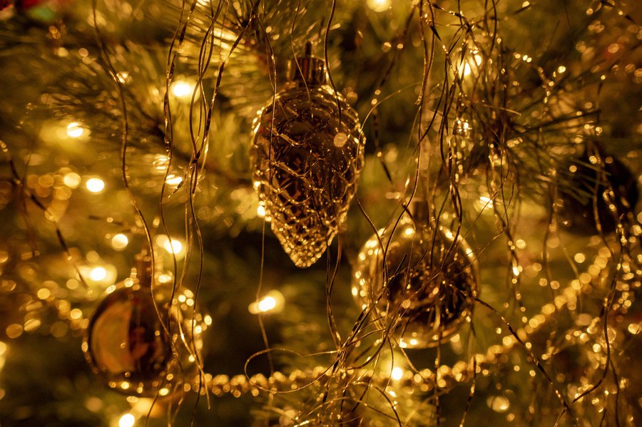 Christbaumschmuck an Baum und goldene Lichter